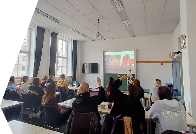 Schüler sitzen im Klassenraum und schauen sich eine Präsentation an 
